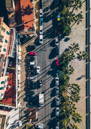 Aerial top view of Italian town by the sea with road, houses, buildings, parks and parking lots.