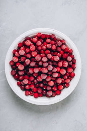 Cranberries. Frozen cranberry in bowl on gray stone background, top view with copy space.の写真素材