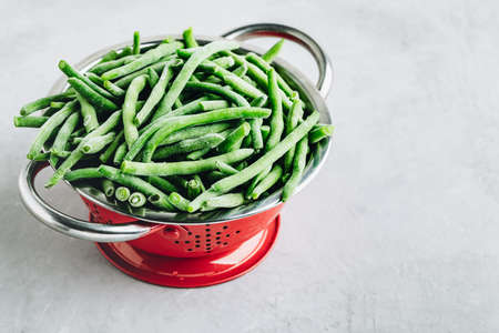 Frozen green beans in a colander ready for cooking with copy space.の写真素材