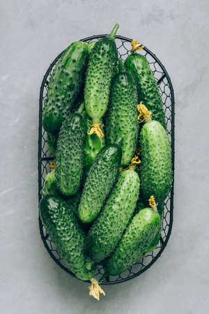 cucumbers. Fresh green organic cucumbers in basket on gray stone background. Top view, copy space.の写真素材