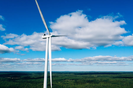 Aerial view of windmills in summer forest in Finland. Wind turbines for electric power with clean...
