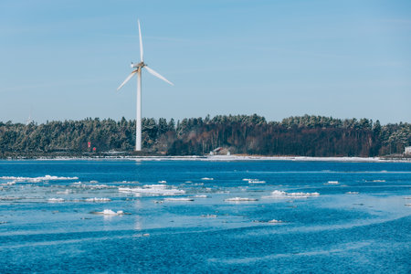 Aerial view Wind turbine by blue sea in snow winter landscape in Finland, Europe. Alternative energy in winter.の写真素材