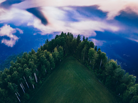 Aerial view of green forest trees and blue lake water with cloud reflection in summer Finlandの写真素材