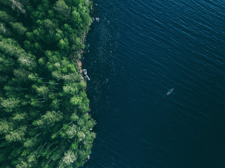 Aerial view fishing boat in blue lake and green woods in summer Finlandの写真素材