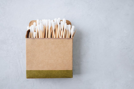 Bamboo ear sticks. Eco-friendly cotton swabs on gray background, top view, copy space. Biodegradable Wooden sticks for cleaning ears. Zero waste, plastic free, sustainable lifestyle conceptの写真素材