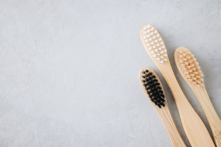 Bamboo toothbrushes. Eco friendly bamboo toothbrushes on gray stone background, top view with copy space. Biodegradable wooden oral hygiene accessories. Zero waste, plastic free, sustainable lifestyle conceptの写真素材