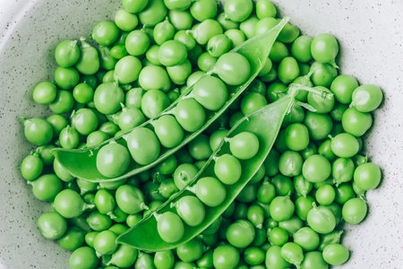 Pea. Green peas pod bowl on gray stone background, top view closeupの写真素材