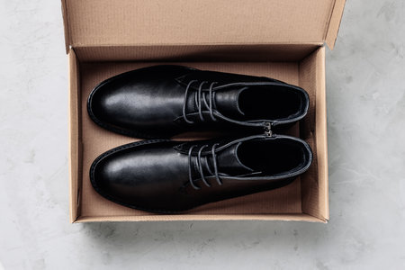 Black Leather men's shoes in brown box on gray stone background. Flat lay top view with copy space.の写真素材