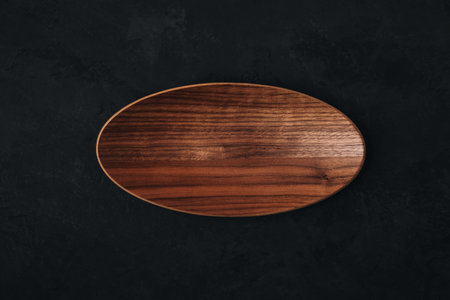 Wooden plate tray on dark stone concrete background, top view.の写真素材