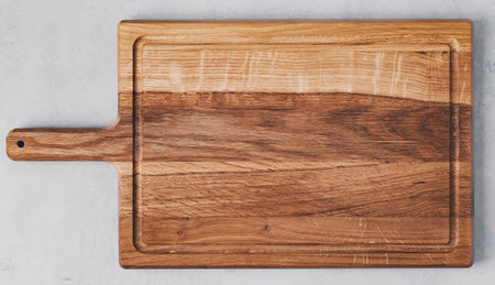 Chopping board. Wooden cutting board on gray concrete stone background. Top view with copy space.