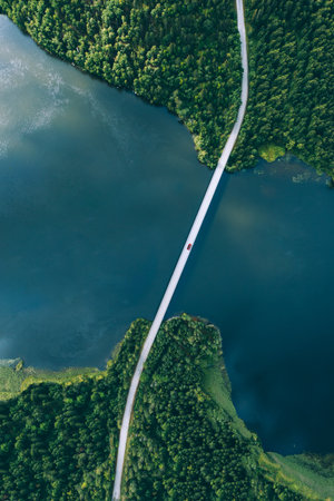 Aerial view of bridge asphalt road with cars and blue water lake and green woods in Finland.の写真素材