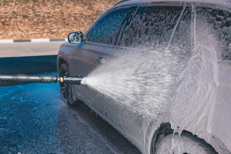 Ð¡ar wash self-service. Man washing luxury vehicle with white foamy detergent. Automobile cleaning self serviceの写真素材