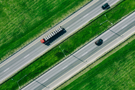 Aerial drone view of highway asphalt road with cars and truck cargoの写真素材