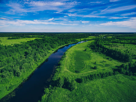 Aerial drone view of blue river. Beautiful blue water river and green summer woods and meadowsの写真素材