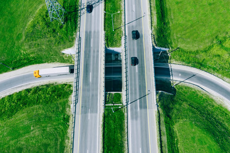 Aerial drone view of highway asphalt road with cars and cargo trucks