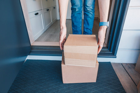Woman picking up a package left on the porch of her house. Concept for delivery and online shopping.