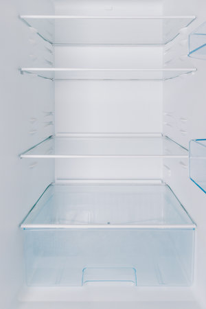 Clean, Empty Refrigerator Interior with Glass Shelves and Storage Drawer for Optimal Food Organization and Freshness Maintenanceの写真素材