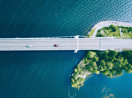 Aerial View of a Serene Bridge Stretching Over a Calm Body of Water Surrounded by Greenery