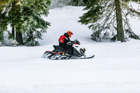 Thrilling Adventure on a Snowmobile Through a Winter Wonderland of Fresh Powder Snow