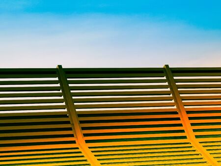 Wooden sun lounger at the beach or on a cruise ship against sunny blue sky