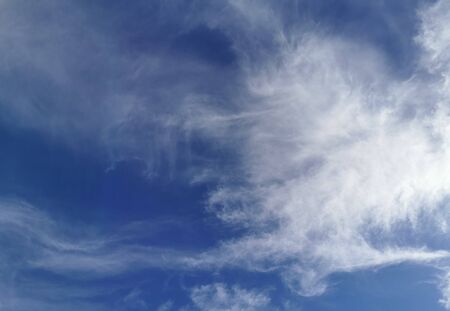 Bright blue sky with clouds, background for design, decoration or wallpaper.