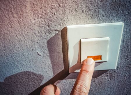A finger pressing door bell or activating a switch giving alert.の写真素材