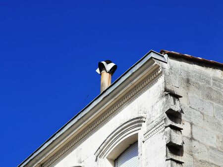 Partial view of a typical ancient house with chimney against blue skyの写真素材