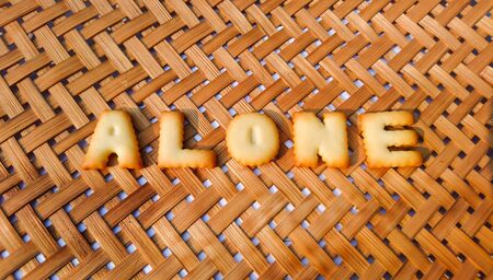 alone alphabet word on brown wood background
