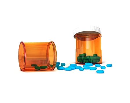 Blue pills poured out of a package on whiteの写真素材