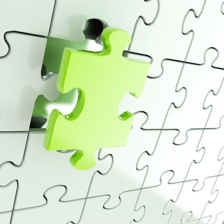 Puzzle jigsaw shiny metal background with one green piece stand outの写真素材