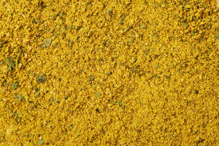 Surface covered with powdered yellow curry seasoning as a background texture compositionの写真素材