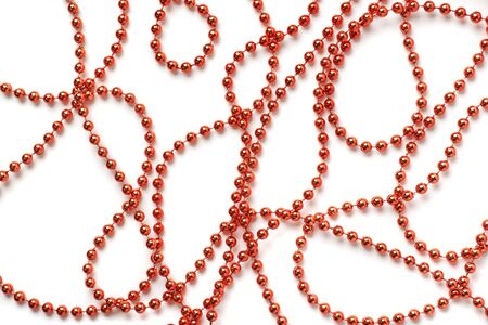 White surface covered with multiple red garland beads thread decorations as an abstract background compositionの写真素材