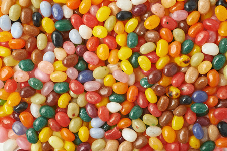 Surface covered with multiple colorful jelly bean candies as a backdrop composition