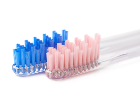 Composition of two toothbrushes with a blue and pink colored bristles isolated over the white...