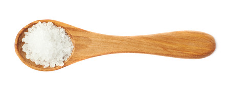 Wooden spoon full of the white rock salt isolated over the white backgroundの写真素材