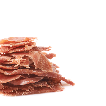 Pile of jamon ham slices isolated over the white backgroundの写真素材