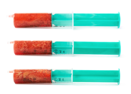 Medical syringe filled with red liquid matter isolated over the white background, set of three different foreshorteningsの写真素材