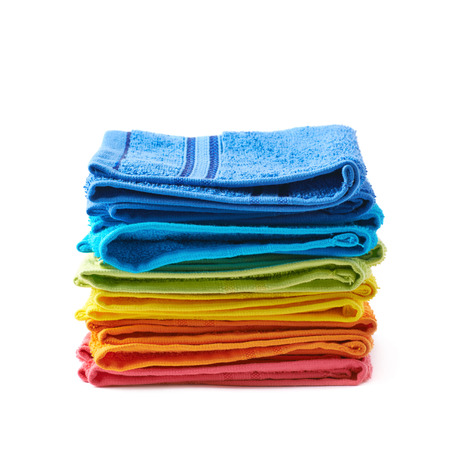 Pile of multiple rainbow colored towels isolated over the white backgroundの写真素材