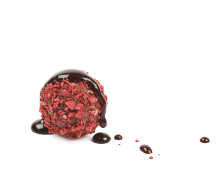 Single handmade red candy ball coated with the hot chocolate, composition isolated over the white backgroundの写真素材