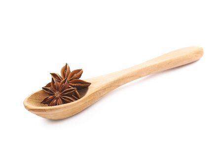 Chinese star anise seed served in a wooden spoon, composition isolated over the white backgroundの写真素材