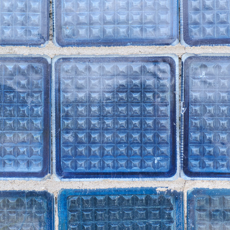 Close-up fragment of a wall made of blue glass bricks as a background texture compositionの写真素材