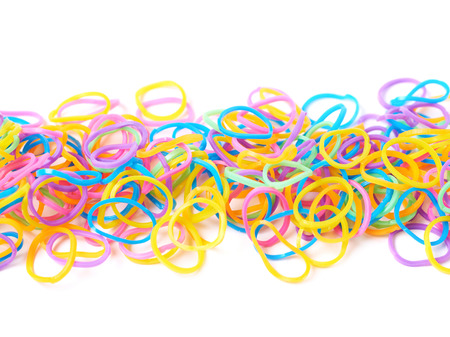 Surface covered with multiple colorful resin loom bands over the white background