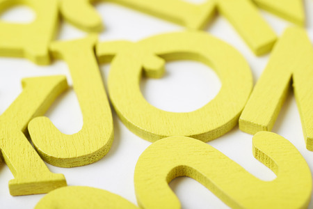 White surface covered with the multiple colorful painted wooden letters as a backdrop compositionの写真素材