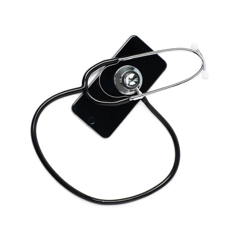 Medical stethoscope tool over the surface of a mobile smart phone, composition isolated over the white backgroundの写真素材