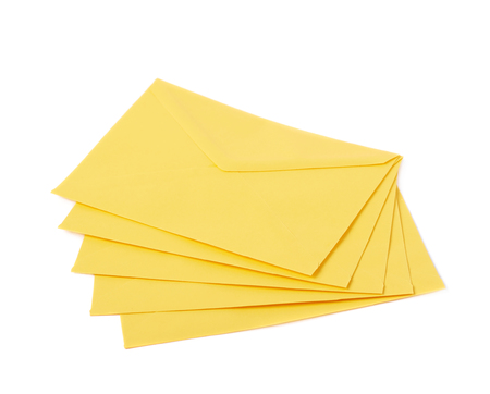 Stack of multiple yellow letter envelopes isolated over the white backgroundの写真素材