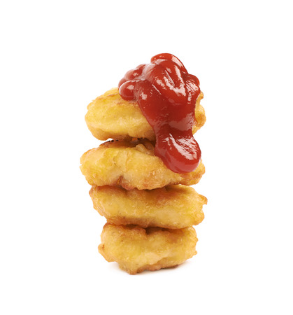 Pile of multiple breaded chicken nuggets covered with ketchup, composition isolated over the white backgroundの写真素材