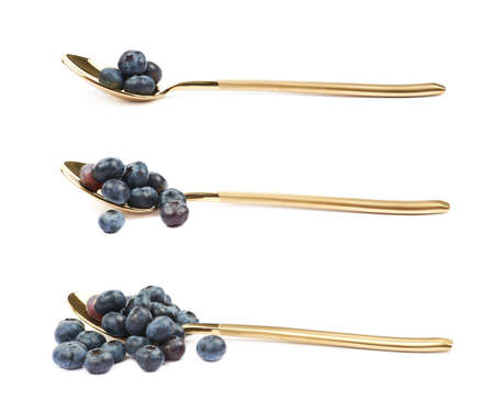 Golden spoon full of bilberries isolated over the white background, set of three different foreshorteningsの写真素材