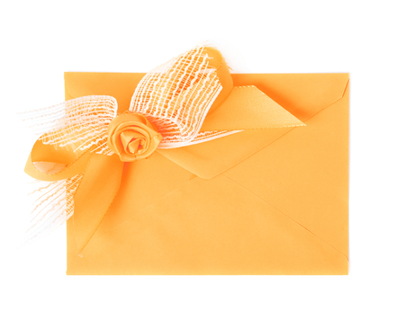 Paper envelope decorated with the bow isolated over the white backgroundの写真素材