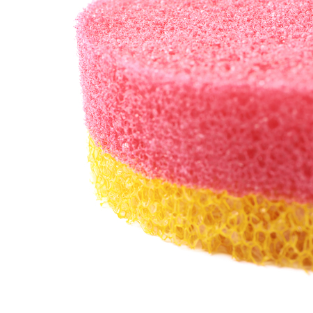 Red and yellow colored bath sponge isolated over the white background, close-up crop fragment as a copyspace backdrop compositionの写真素材