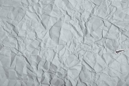 Close-up fragment of a gray crumpled paper texture as a backdrop compositionの写真素材